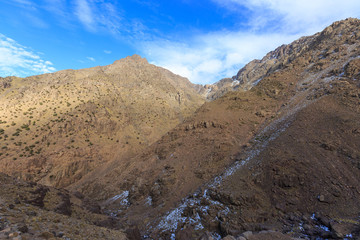 Atlas Mountains. Mountain slope with snow on walking hiking trail. Morocco, winter. Wild nature landscape.