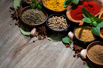 assortment of various spices and herbs on a wooden background, top view