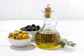 bottle with olive oil and bowls with olives