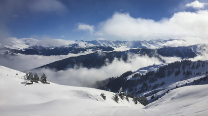 Snow covered Alps with clouds in the valley