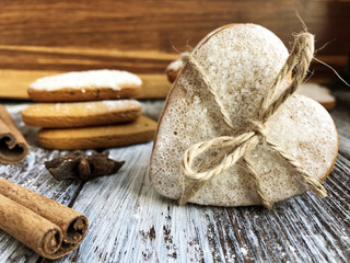 Heart shaped ginger cookies with twine and spice on wooden background. Homemade backing. Love or Valentine's day concept.