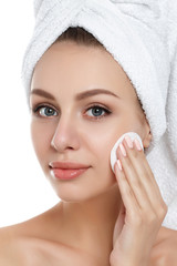 Young woman with towel on her hair cleaning makeup