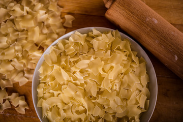 dry square pasta shapes in white bowl plate on wood table 