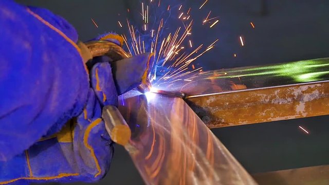 Worker with protective mask welding metal welding, welder, steel . A man welds a metal with a welding machine