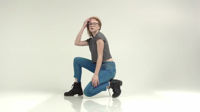 Beautiful red-haired girl with glasses on a white background