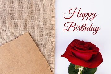 Birthday card with beautyful red rose on the white empty background with natural jute and old paper