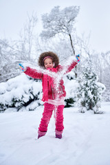 Fototapeta na wymiar Little girl in red clothes, playing on snow