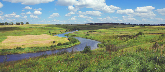 Sunny summer landscape.Green hills with growing trees.River Upa in Tula region, Russia.Countryside scene.Panoramic view.
