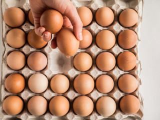 Hand folding out eggs in the package.