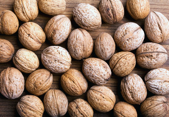 few closed ripen walnuts on an old walnut board