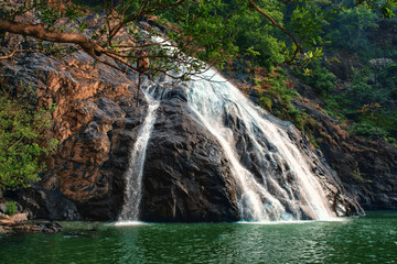 waterfall flows through the rocks and flows into the lake India, Dudhsagar