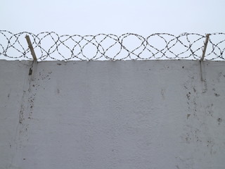 white concrete fence with barbed wire
