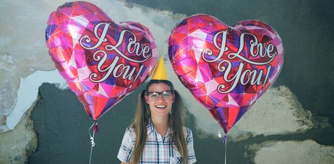 Composite image of geeky hipster holding balloons 