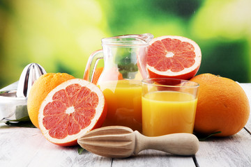 Fototapeta na wymiar Glass of grapefruit juice and slices of orange fruit on wooden background.