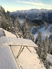 Verschneites Vordach auf der Bergstation der Laber-Bergbahn mit imposantem Panorama der Alpen auf...