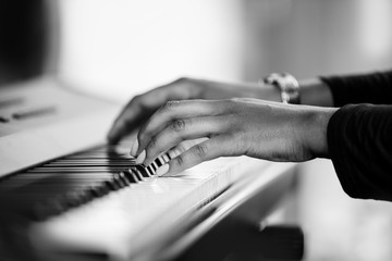Close up of hands playing a piano. Black and white image of pianists hands.
