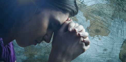 Composite image of close up of woman praying with hands together