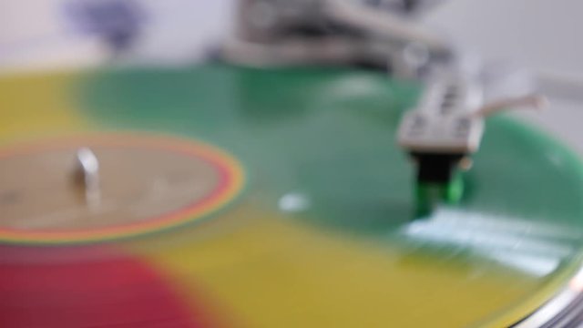 beautiful blurred background vinyl record red yellow green colors revolving on a record player close-up