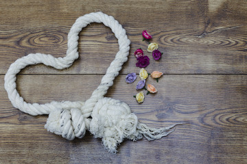 Heart shaped rope and flowers on wood. valentine's day decor.