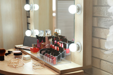 Decorative cosmetics and tools on dressing table in makeup room