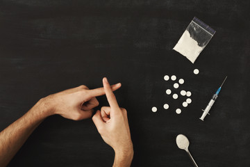 Man's hands showing stop sign on dark table