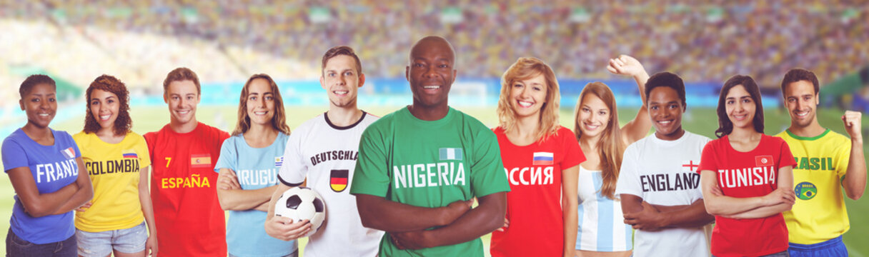 Nigerianischer Fussball Fan im Stadion mit Gruppe internationaler Fans 