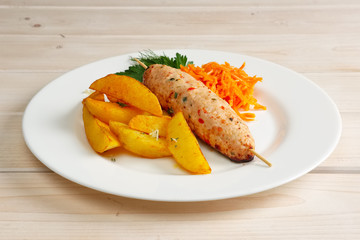 Kebab on skewer with fried potato and spicy carrot