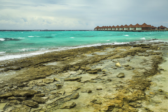 low tide on the beach and view to bungalows on Maldives island