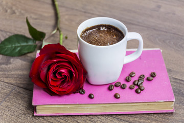 coffee cup with red rose and pink book