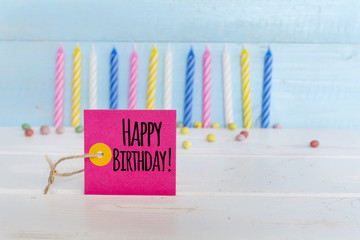 birthday candles and happy birthday sign isolated on a wooden background