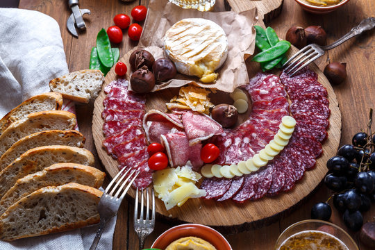 Close View Of Mix Of Delicious Meat Snacks On Wooden Board.