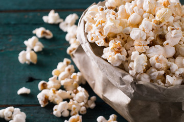 Salt popcorn on the wooden table, selective focus