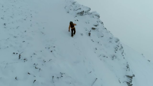 Mountain Climber on a Difficult Ascent Using Ice Axe in a Whiteout