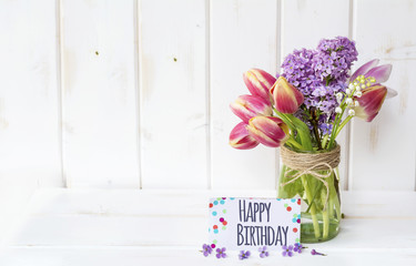 beautiful bouquet of tulips and lilac  with  happy birthday  message card 