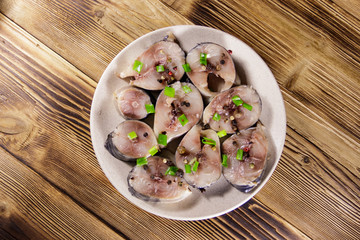 Sliced mackerel with spices on wooden table. Salted scomber on a plate