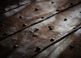 Surface of the old rusty bound chest with rivets and nail heads. Light and shadow game. Vintage...