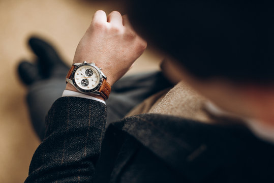 Businessman is checking time on his modern wrist watch. Top view