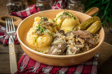 Fried chicken liver with onion served with mashed potatoes and pickled cucumber.
