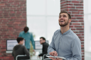 Image of a cheerful businessman working on a tablet in the offic