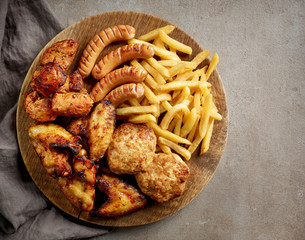 various fried meat and potatoes on wooden board