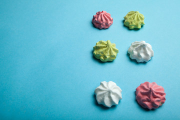 Homemade meringue with love on a blue background, space for text.