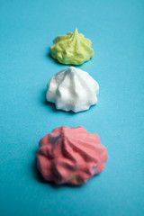 A concept of a children's holiday, crispy meringues on a blue background.