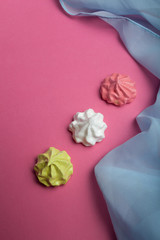 Sweet French meringue on a pink background for Valentine's Day.