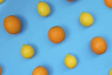 Top view of colorful fruit pattern of fresh orange and lemon on blue background