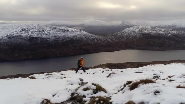 Mountain Climber and Scottish Highlands with a Loch Below