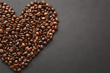 Brown coffee beans in form of heart isolated on black texture background for design, part or half. Saint Valentine's Day card on fabruary 14, holiday concept.