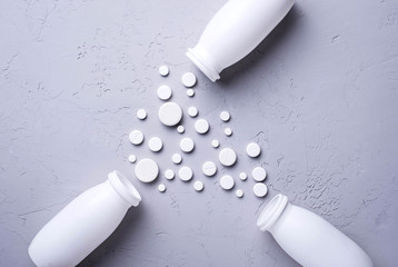 Different pills and tablets on grey background