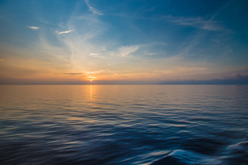 Sunset at the horizon at sea