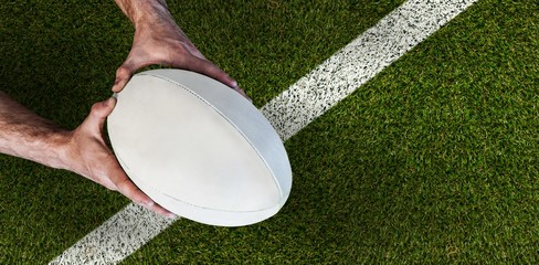 Composite image of man holding rugby ball - Powered by Adobe