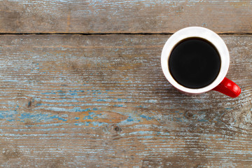 Coffee cup on old wooden table background. Top view with copy space
